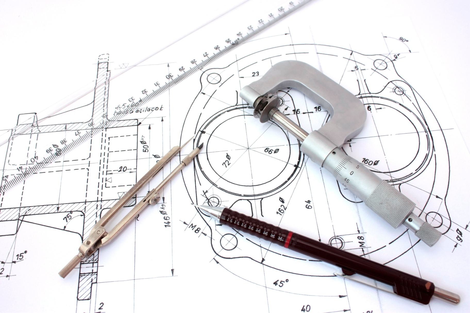 Engineering drawing and precision measuring tools used during medical device development