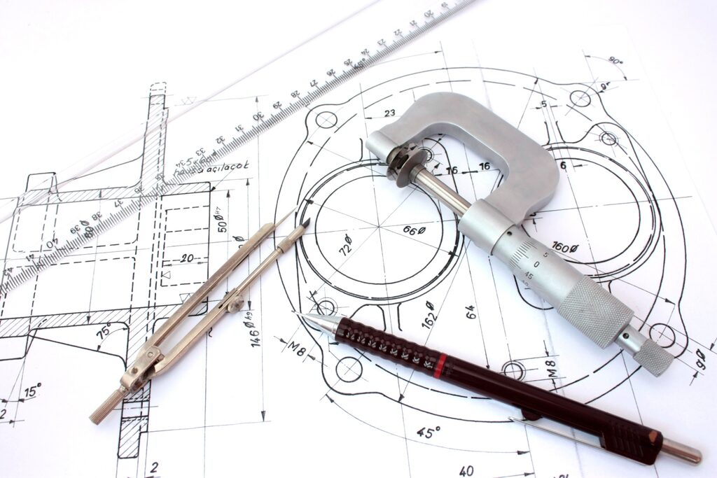 Engineering drawing and precision measuring tools used during medical device development